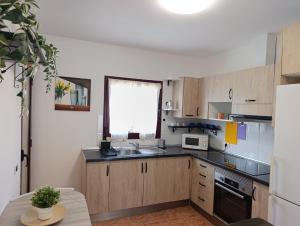 a small kitchen with a sink and a microwave at Bahia Sol Dream -Caleta de Fuste- in Caleta De Fuste