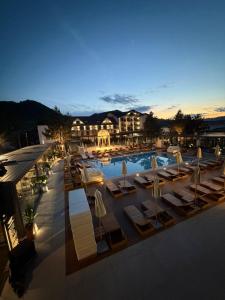 a swimming pool with lounge chairs and umbrellas at night at Verde by Hotel Gabriela in Vişeu de Sus