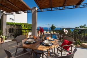 a table and chairs on a patio with a view at Apartments Oktopus in Sutomore