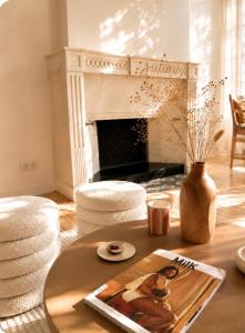 a living room with a table and a fireplace at Maison du temps lent Centre historique en Arbois Escapade Romantique in Arbois