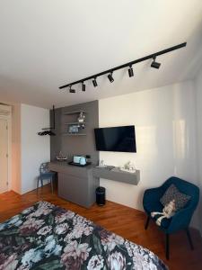 a bedroom with a bed and a chair and a television at Room with jungle bathroom in Dubrovnik