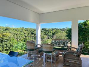 a screened in porch with chairs and a glass table at Casa Guimarães II in Chapada dos Guimarães