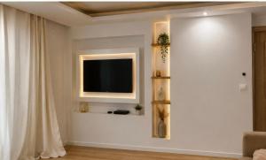 a living room with a television on a wall at Grande Villa de Prestige près de Paris Réunions Familiales, Professionnelles et Événements in Gien