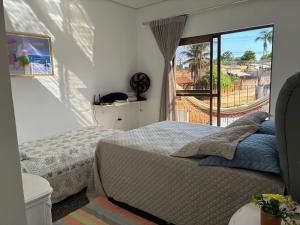 a bedroom with a bed and a window with a view at Casa Guimarães II in Chapada dos Guimarães +32 photos