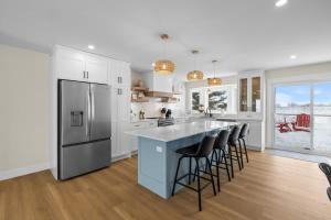 a kitchen with a large island with bar stools at The Lantern Hill Lookout in North Rustico