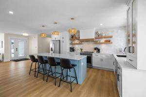 a kitchen with a blue island with bar stools at The Lantern Hill Lookout in North Rustico