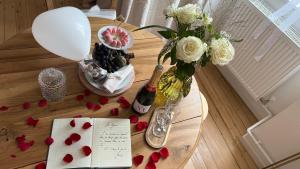 a table with a vase of flowers and a bottle of champagne at Maison du temps lent Centre historique en Arbois Escapade Romantique in Arbois