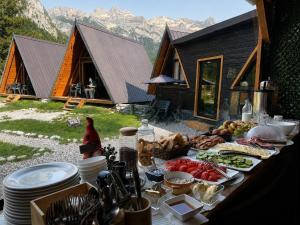a table with food on it in front of a cabin at Thethi Villas in Theth
