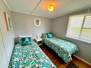 a bedroom with two beds and a window at River Cottage on Cherry - Pet Friendly in Evans Head