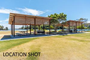 a pavilion with tables and benches in a park at River Cottage on Cherry - Pet Friendly in Evans Head