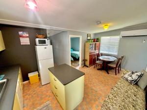 a kitchen and dining room with a refrigerator and a table at River Cottage on Cherry - Pet Friendly in Evans Head