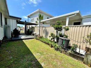 a backyard of a house with a fence at River Cottage on Cherry - Pet Friendly in Evans Head +6 photos