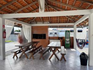 a group of picnic tables and benches under a pavilion at Pousada Siri do Mar in Pontal do Paraná
