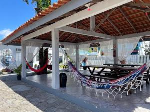 a patio with a hammock and a table and chairs at Pousada Siri do Mar in Pontal do Paraná