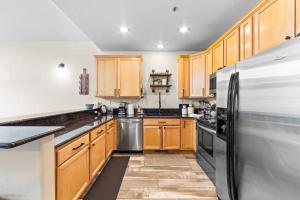 a kitchen with wooden cabinets and a stainless steel refrigerator at La Riva Del Lago #204 in Dillon