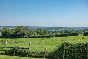 a field of green grass with a fence at Airy Barn Conversion Private Parking & Garden in Burrington