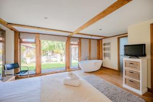 a bedroom with a tub and a tv and a bed at Airy Barn Conversion Private Parking & Garden in Burrington +23 photos