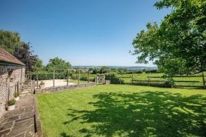 a garden with a fence and a field at Airy Barn Conversion Private Parking & Garden in Burrington