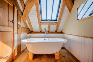 a bath tub in a bathroom with a window at Cosy Barn Conversion with Patio & Private Parking in Burrington