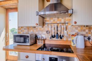 a kitchen with a counter top with a microwave at Cosy Barn Conversion with Patio & Private Parking in Burrington