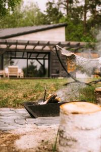 a person laying around a fire in a fire pit at Nomad Cabin Roztocze in Tereszpol Zaorenda