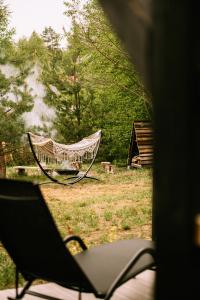 a hammock sitting in a field of grass at Nomad Cabin Roztocze in Tereszpol Zaorenda