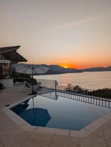 a swimming pool with a sunset in the background at Rustic house with stunning lake view in Valle de Bravo