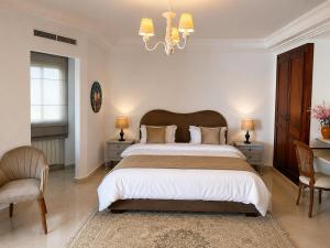 a bedroom with a large bed and a chandelier at Alya Residence in La Marsa +12 photos