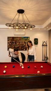 a man and woman standing next to a pool table at Alya Residence in La Marsa
