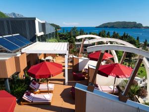 a balcony with chairs and umbrellas and the ocean at Hotel Imperial Conference & Spa in Budva