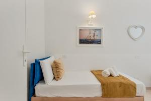 a bedroom with a white bed with a heart picture on the wall at GOLDEN LUXE - Sunset by the Sea in Lido di Camaiore