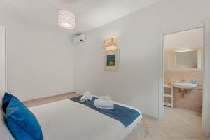 a white bedroom with a bed and a sink at GOLDEN LUXE - Sunset by the Sea in Lido di Camaiore
