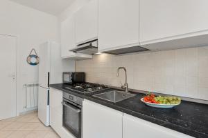 a kitchen with a sink and a bowl of fruit on the counter at GOLDEN LUXE - Sunset by the Sea in Lido di Camaiore