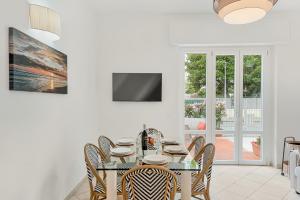 a white dining room with a table and chairs at GOLDEN LUXE - Sunset by the Sea in Lido di Camaiore +9 photos