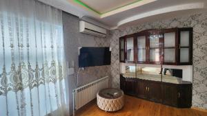 a living room with a cabinet and a television at Sheki Garden Guest House in Sheki