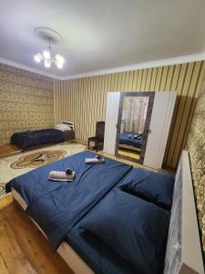 a bedroom with a large bed with blue sheets at Sheki Garden Guest House in Sheki
