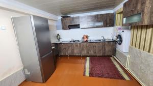 a kitchen with a refrigerator and a washing machine at Sheki Garden Guest House in Sheki