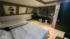 a hospital room with two beds and a television at Sixty Hotel in Seoul