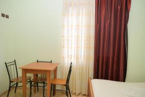 a bedroom with a table and chairs and a bed at Hotel Xhejsoni in Shëngjin