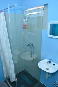 a bathroom with a glass shower and a sink at Cantinho C - Alojamento Complementar in Praia +47 photos