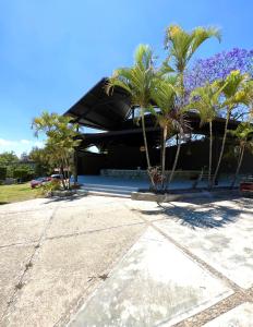 a building with palm trees in front of it at Estancia las Jacarandas Cabañas in San Gabriel Etla