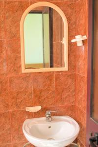 a bathroom with a sink and a mirror at Hotel Xhejsoni in Shëngjin