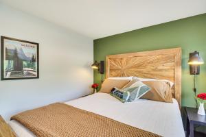 a bedroom with a bed with a wooden headboard at Gateway to Glacier! 2-Cabin Compound for Groups in Columbia Falls
