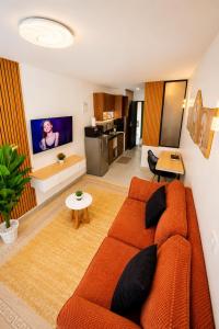 a living room with an orange couch and a kitchen at Ongata Rongai Pool Studio Near Nairobi National Park and giraffe center in Ongata Rongai 