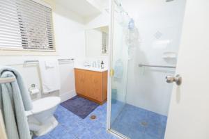 a bathroom with a shower and a toilet and a sink at Lomandra in Evans Head +7 photos