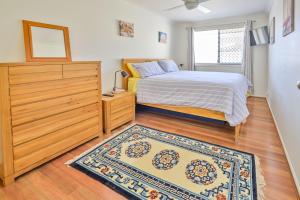 a bedroom with a bed and a dresser and a rug at Lomandra in Evans Head