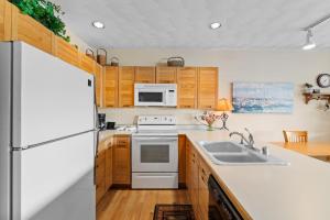 a kitchen with white appliances and wooden cabinets at East Bay Condos #111 in Dillon