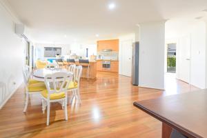 a kitchen and dining room with a table and chairs at Lomandra in Evans Head