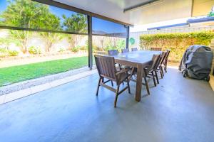 a dining table and chairs on a patio at Lomandra in Evans Head