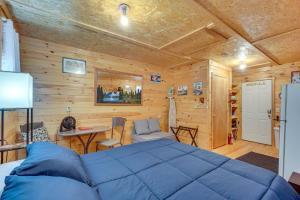 a bedroom with a blue bed in a wooden room at House & Tiny Cabin! Multi-Acre East TN Property in Englewood